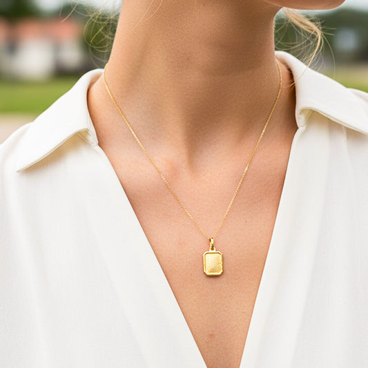 Cuello de modelo usando una cadena con un dije en forma de placa de colmena en oro amarillo de 18 quilates de Joyería Caracas.