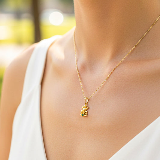 Cuello de modelo usando una cadena con un dije Precolombino en forma de en oro amarillo de 18 quilates de Joyería Caracas.