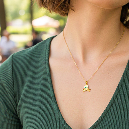 Cuello de modelo usando una cadena con un dije en forma de pulpo en oro amarillo de 18 quilates con 2 cristales verdes de Joyería Caracas.