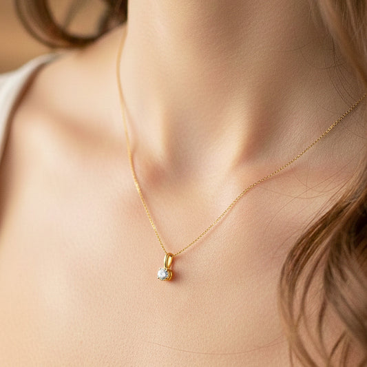 Cuello de modelo usando una cadena con un dije en oro amarillo de 18 quilates con cristal en corte redondo de Joyería Caracas.