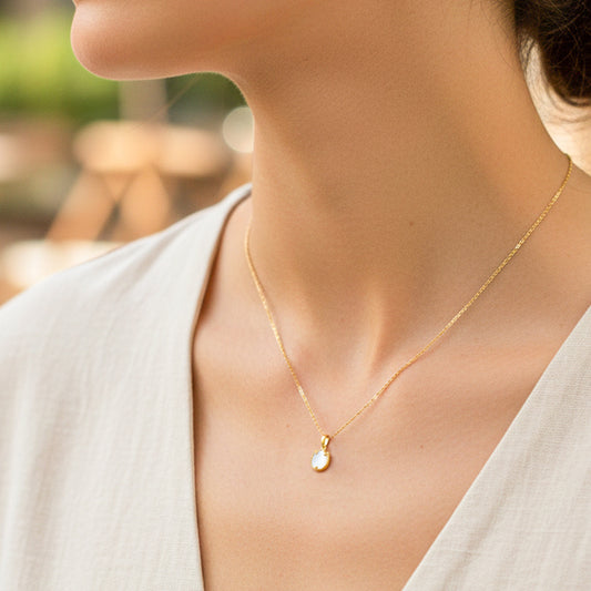 Cuello de modelo usando una cadena con dije en forma de tulipán en oro amarillo de 18 quilates con Nacar blanco de Joyería Caracas.