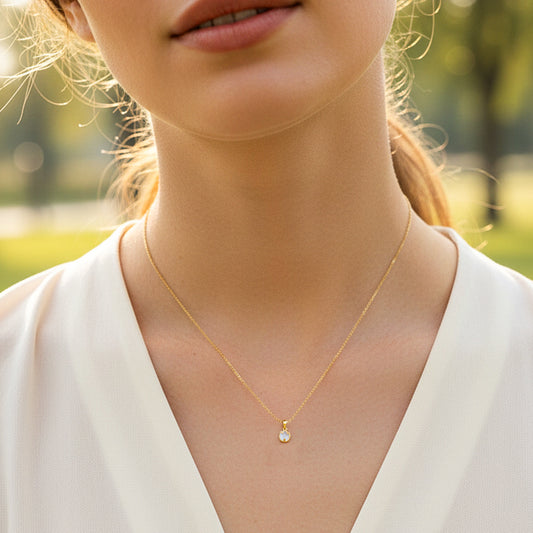 Cuello de modelo usando una cadena con dije en forma de tulipán en oro amarillo de 18 quilates con Nacar blanco de Joyería Caracas.