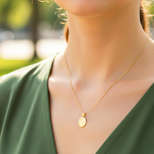 Cuello de modelo usando una cadena con un dije de la Virgen de Guadalupe en grabado láser en oro amarillo de 18 quilates de Joyería Caracas.