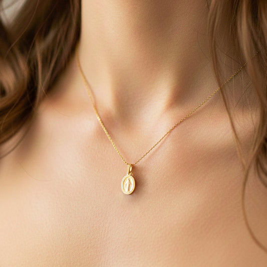 Cuello de modelo usando una cadena con dije de la Virgen Milagrosa en oro amarillo de 18 quilates de Joyería Caracas.