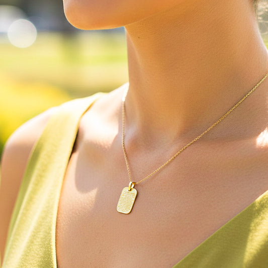 Cuello de modelo usando una cadena con dije de placa del Padre Nuestro en oro amarillo de 18 quilates de Joyería Caracas.