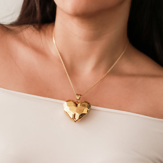 Cuello de mujer usando una cadena con un dije en forma de corazón electro formado en oro amarillo de 18 quilates de Joyería Caracas.