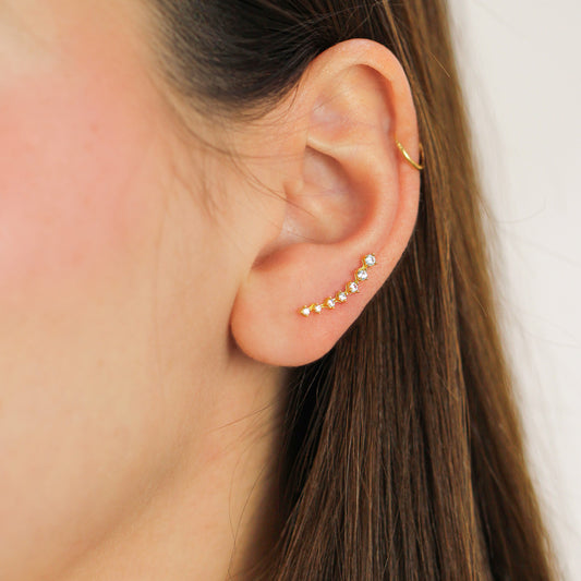 Oreja de mujer con topito caterpillar en oro amarillo de 18 quilates con cristales de color blanco, hechos en Joyería Caracas.