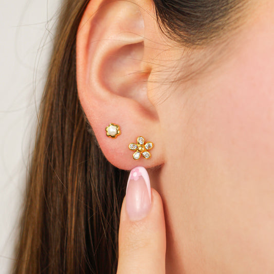 Oreja de mujer con topito en forma de flor de 5 pétalos en oro amarillo de 18 quilates con cristales de color blanco, hechos en Joyería Caracas.