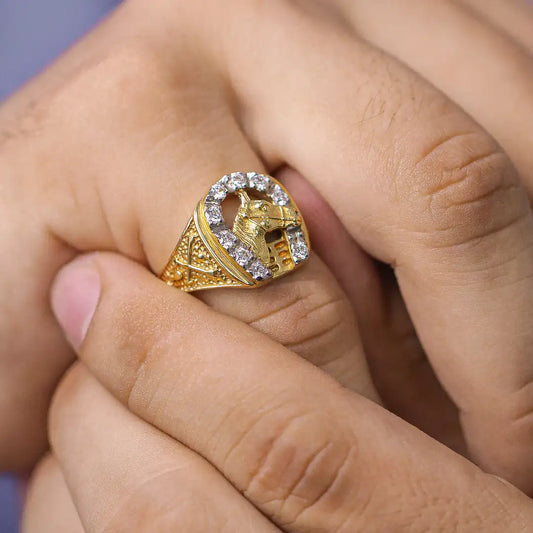 Mano de hombre con anillo en forma de herradura con caballo en el centro en oro amarillo y blanco de 18 quilates, hecho en Joyería Caracas.