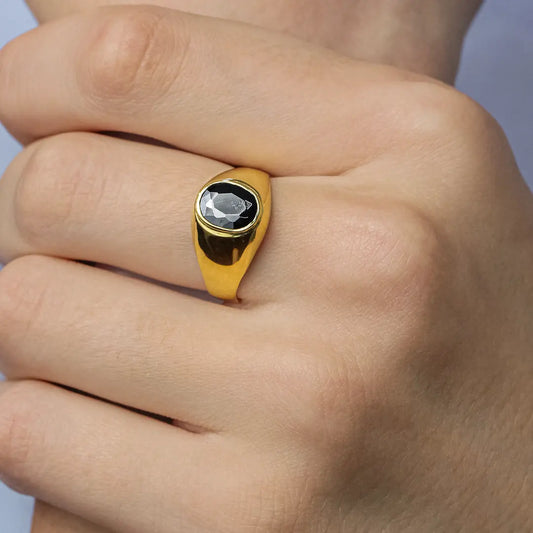 Mano de hombre con anillo en oro amarillo de 18 quilates con cristal de color negro en el centro, hecho en Joyería Caracas.
