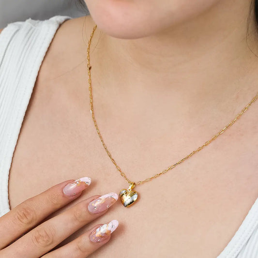 Cuello de mujer con cadena y dije en forma de corazón en oro amarillo, blanco y rosa de 18 quilates, hecho en Joyería Caracas.