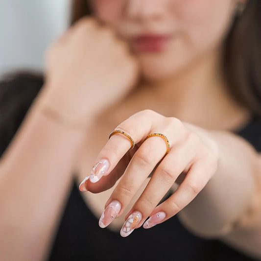Mano de mujer con anillo en oro amarillo de 18 quilates con cristales de distintos colores, hecho en Joyería Caracas.