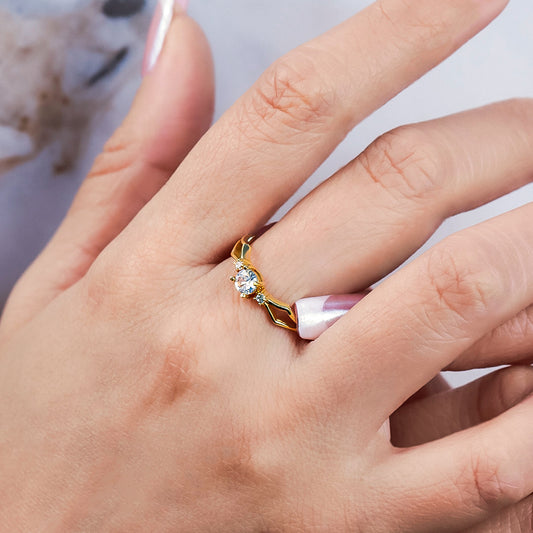 Mano de mujer con anillo en oro amarillo de 18 quilates con 3 cristales de color blanco, hecho en Joyería Caracas.