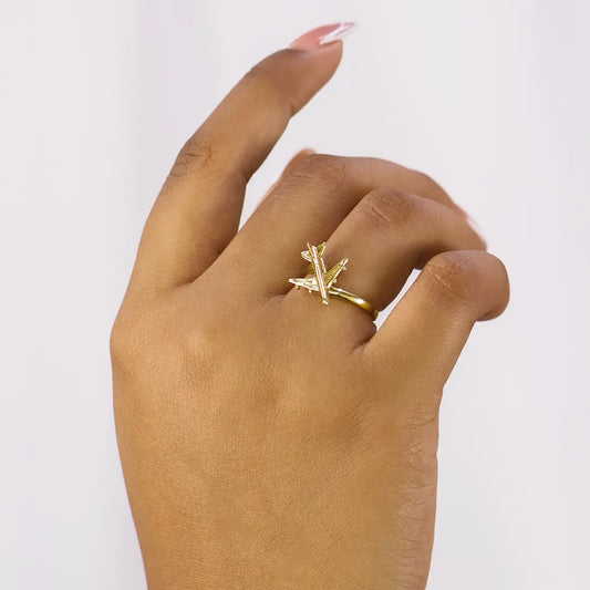Mano de mujer con anillo en forma de avión en oro amarillo de 18 quilates, hecho en Joyería Caracas.