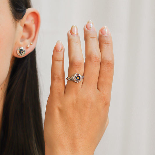 Mano de mujer con anillo inspirado en la apariencia de un pulpo en oro blanco de 18 quilates con piedra preciosa Zafiro en el centro y Diamantes de color blanco alrededor de él.