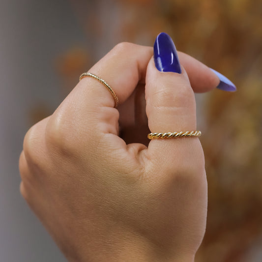 Mano de mujer usando anillo en forma de lazo en oro amarillo de 18 quilates, hecho en Joyería Caracas.