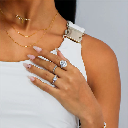 Mano de mujer usando anillo con cuadrado en el centro en oro blanco de 18 quilates y cristales de color blanco, hecho en Joyería Caracas.