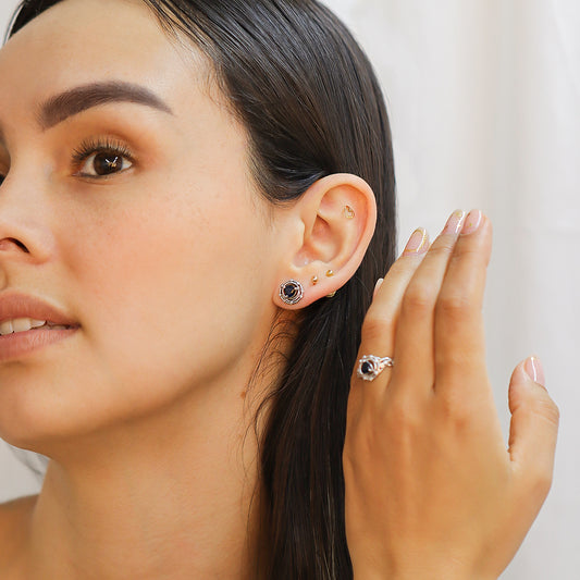 Modelo mujer posando con un set topitos anillos en oro blanco con zafiros en forma de corazon.