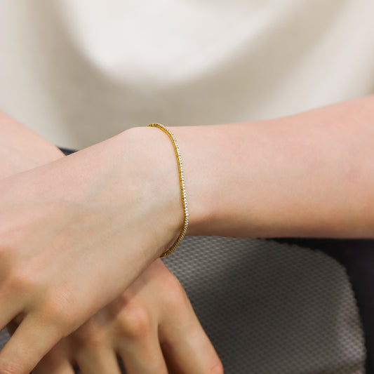 Mano de hombre con pulsera Tennis de 19cm en oro amarillo de 18 quilates con cristales de color blanco, hecho en Joyería Caracas.