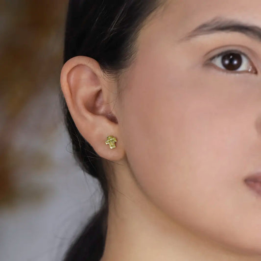 Oreja de mujer con topito en forma de cruz en oro amarillo de 18 quilates, hechos en Joyería Caracas.