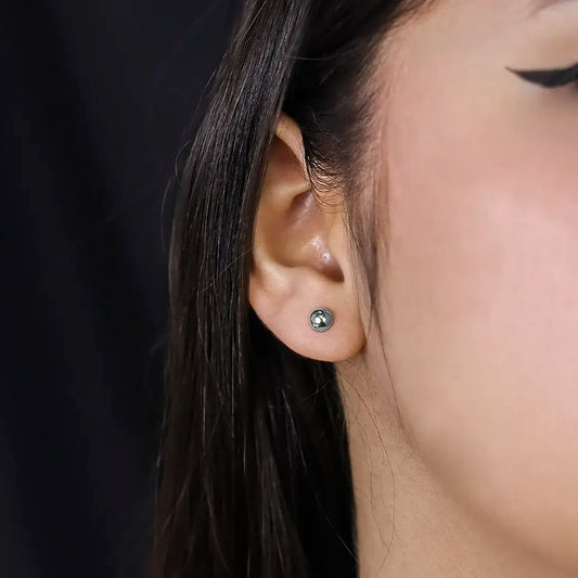 Oreja de mujer con topitos de esfera lisa de 5.0mm en oro blanco de 18 quilates, hechos en Joyería Caracas.