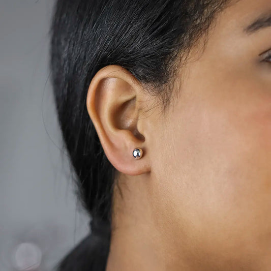 Oreja de mujer con topito de esfera lisa de 6.0mm en oro blanco de 18 quilates, hechos en Joyería Caracas.