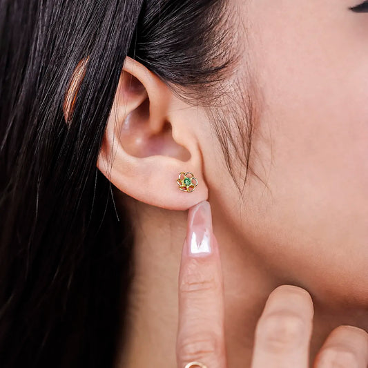 Oreja de mujer con topito en forma de flor calada en oro amarillo de 18 quilates con centro de cristal de color verde, hecho en Joyería Caracas.