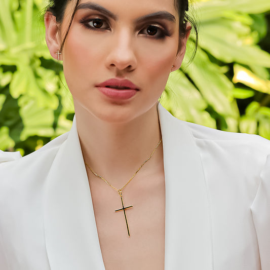 Cuello de mujer con cadena y dije en forma de cruz en oro amarillo de 18 quilates, hecho en Joyería Caracas.