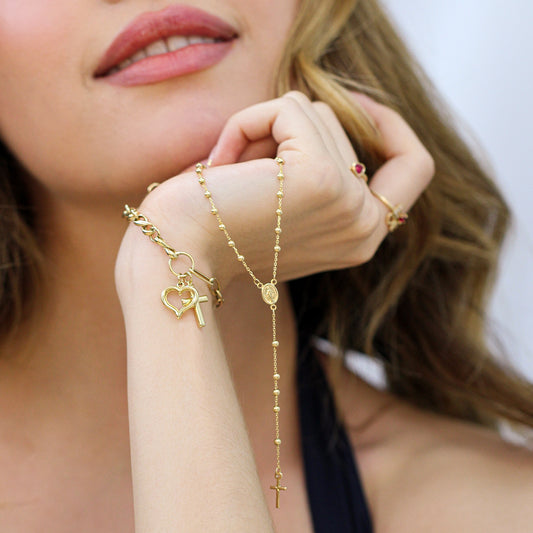 Mujer usando un rosario en oro amarillo de 18 quilates de Joyería Caracas.