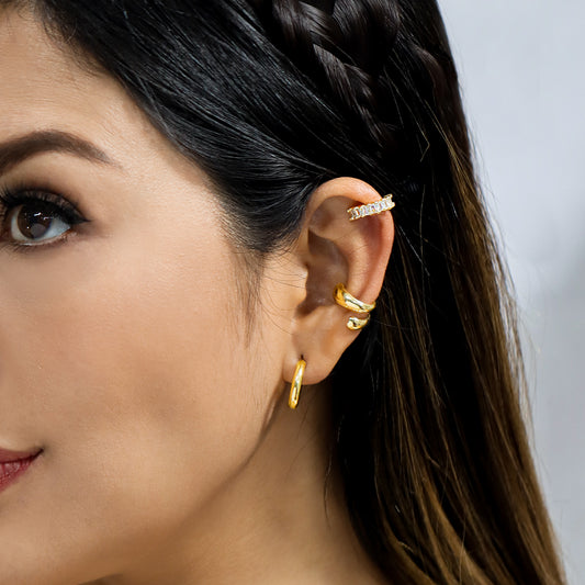 Oreja de mujer con earcuff en color amarillo de 18 quilates con cristales de color blanco, hecho en Joyería Caracas.
