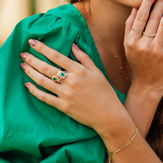 Mano de mujer usando una pulsera de clips con mini esferas en oro amarillo de 18 quilates.