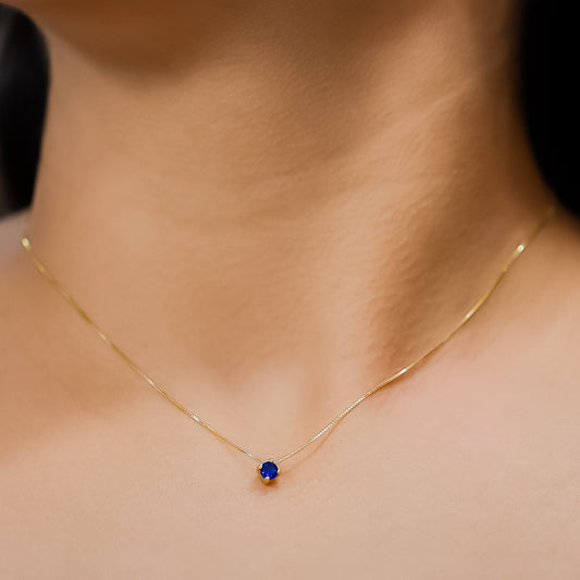 Cuello de mujer con gargantilla en oro amarillo de 18 quilates con cristal de color azul, hecho en Joyería Caracas.