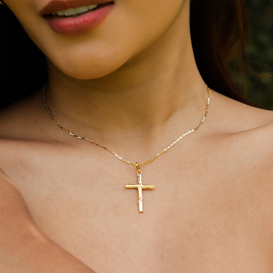Cuello de mujer con cadena y dije de Cruz entorchada en oro amarillo de 18 quilates, hecho en Joyería Caracas.