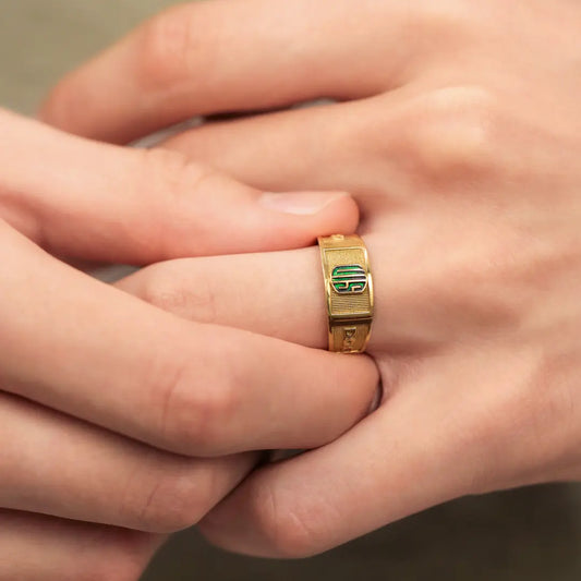 Mano de hombre con anillo de grado en oro amarillo de 18k, hecho en Joyería Caracas.