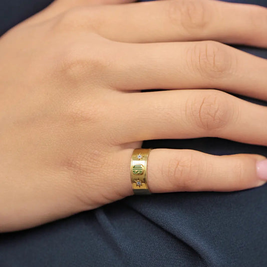 Mano de hombre con anillo de grado en oro amarillo de 18k con 2 cristales de color blanco, hecho en Joyería Caracas.