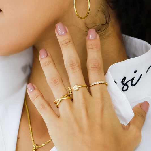 Mano de mujer con anillo de 2 líneas en forma de equis en oro amarillo de 18 quilates, hecho en Joyería Caracas.