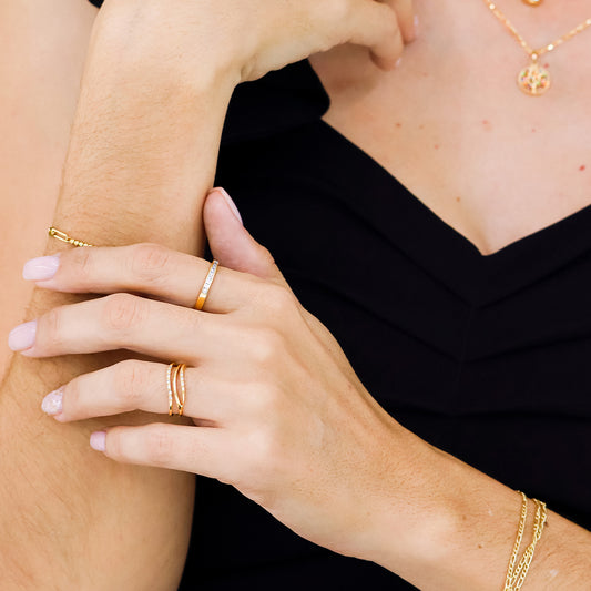 Mano de mujer con anillo en oro amarillo de 18 quilates con cristales de color blanco, hecho en Joyería Caracas.