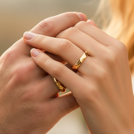 Mano de pareja usando unas argollas de matrimonio en oro amarillo de 18 quilates de Joyería Caracas.