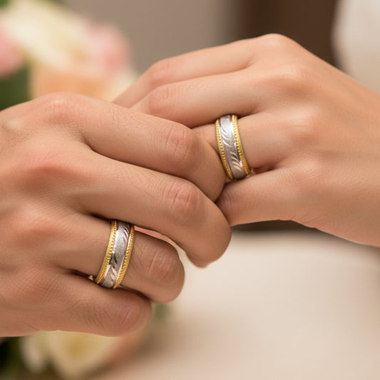 Mano de pareja usando unas argollas de matrimonio facetadas en oro amarillo y blanco de 18 quilates de Joyería Caracas.