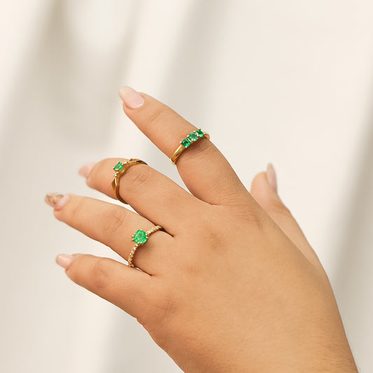 Mano de mujer con anillo en oro amarillo de 18 quilates con 3 Esmeraldas naturales de color verde, fabricado en Joyería Caracas.
