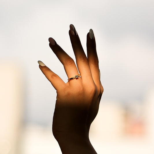 Mano de mujer con anillo solitario en oro amarillo de 18 quilates con Diamante en el centro de color blanco y alrededor.