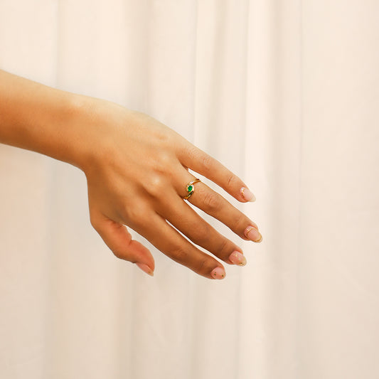 Mano de mujer con anillo en oro amarillo de 18 quilates con esmeralda de color verde en el centro, fabricado en Joyería Caracas.