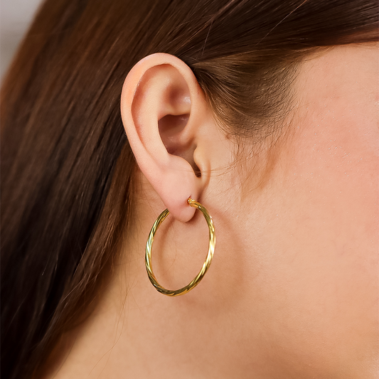 Oreja de mujer con candongas en forma de melcocha en oro amarillo de 18 quilates de Joyería Caracas.