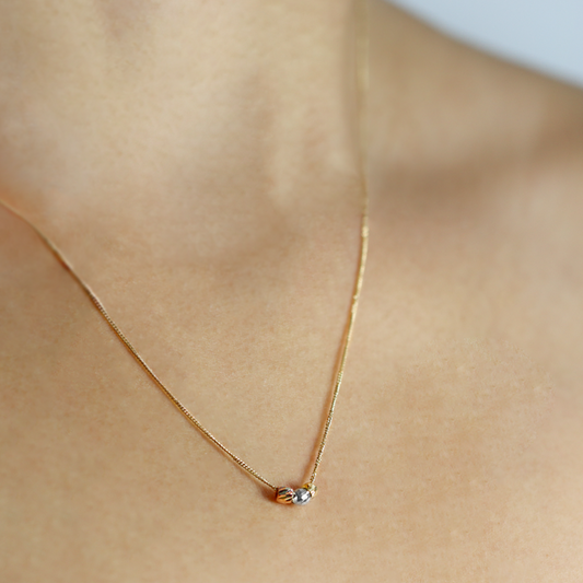 Cuello de mujer usando gargantilla mini cubana de 3 esferas facetadas en oro amarillo, blanco y rosa de 18 quilates, hecho en Joyería Caracas.