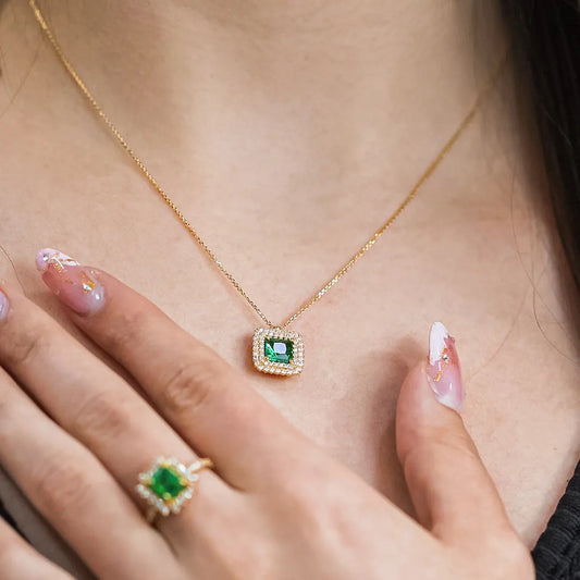Cuello de mujer usando gargantilla con dije en oro amarillo de 18 quilates con cristal de color verde en el centro y cristales de color blanco, hecho en Joyería Caracas.
