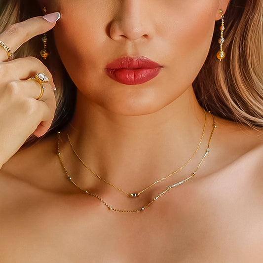 Cuello de mujer usando una gargantilla en tejido Singapur con mini esferas en oro amarillo, blanco y rosa de 18 quilates en Joyería Caracas.