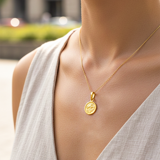 Cuello de modelo usando una cadena con un dije en forma del signo zodiacal de Acuario en oro amarillo de 18 quilates de Joyería Caracas.