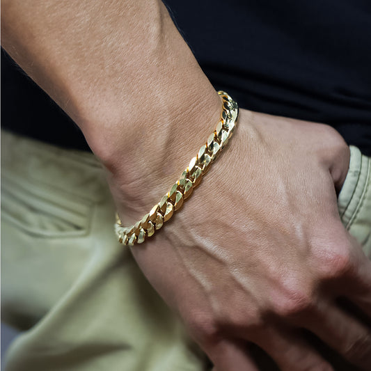 Mano de hombre usando una pulsera en tejido cubano especial XL en oro amarillo de 18 quilates en Joyería Caracas.