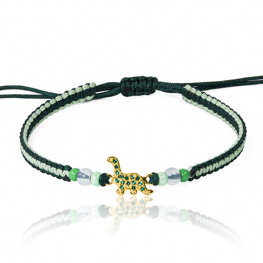 Pulsera Dino de Joyería Caracas está hecha en oro 18k, con detalles en hilo coreano y bisutería de calidad. Con garantía de por vida y sin costo adicional.