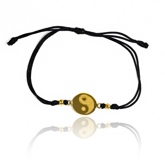 Pulsera Yin y Yang de Joyería Caracas está elaborada en oro 18k, con detalles en hilo coreano y bisutería de calidad. Con garantía de por vida y sin costo adicional.
